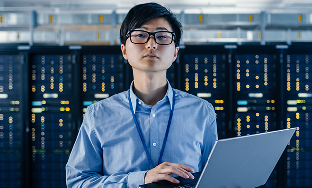 Datacenter engineer analyzing business-related security information on laptop